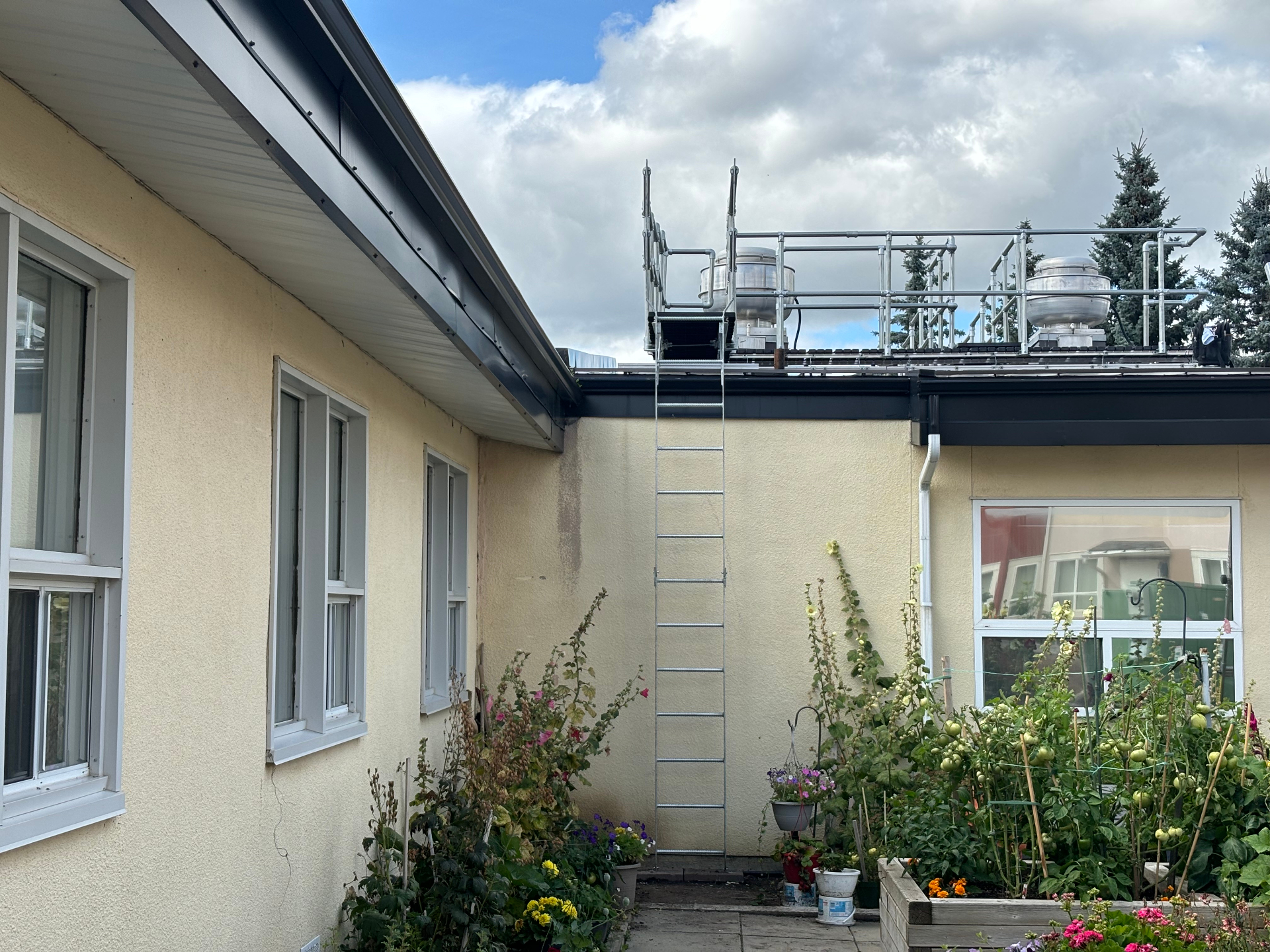 Custom rooftop access stairs, walkway, and guardrail system installed above a courtyard