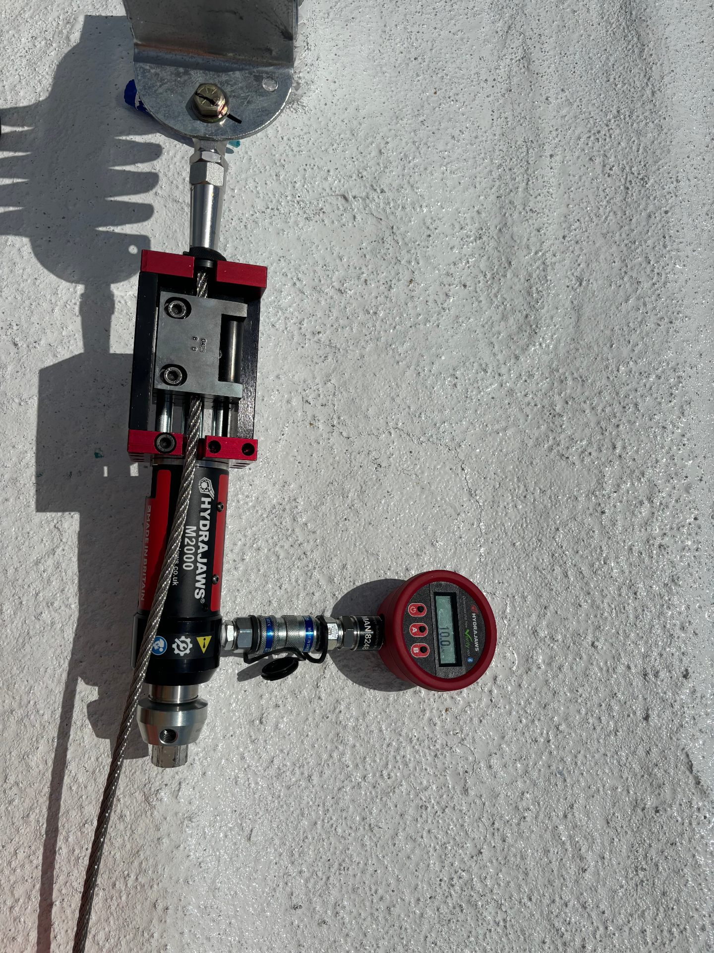 Swage termination on a rooftop lifeline anchor under proof load with a Hydrajaws digital gauge