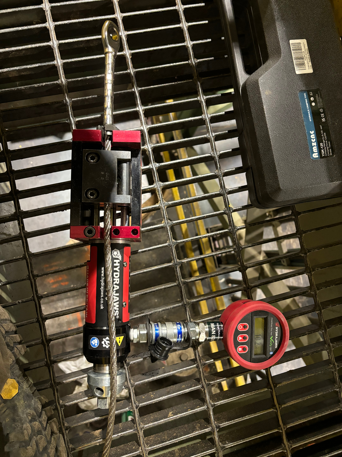 Overhead view of a swaged cable termination under load on industrial grating
