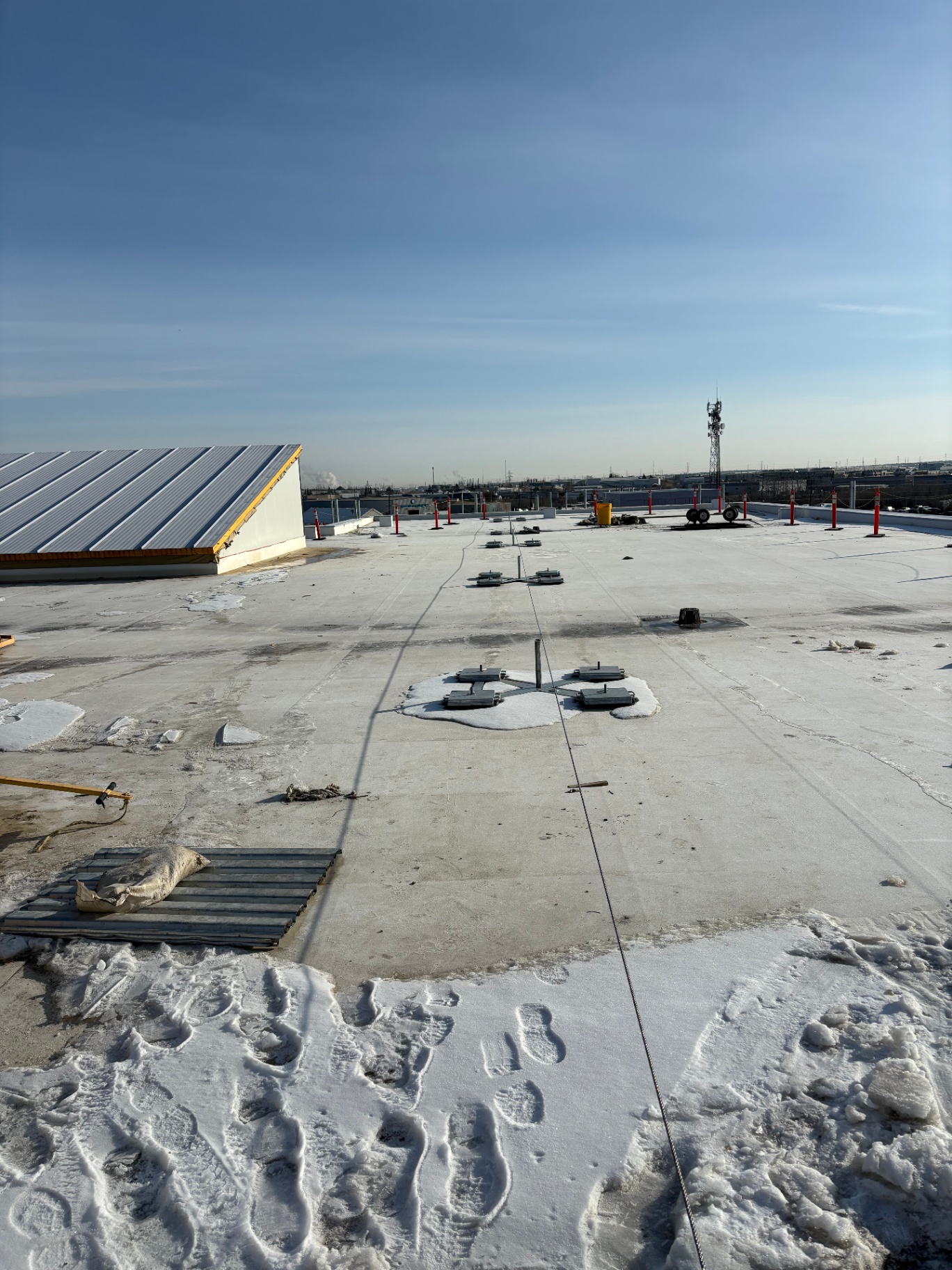 Non-penetrating horizontal lifeline system laid out across a flat roof to show anchor spacing and cable run design